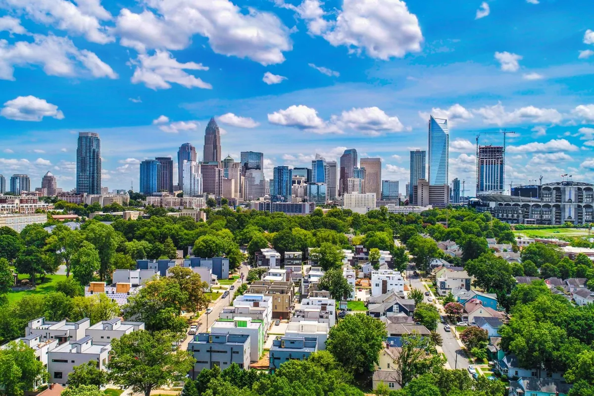 A panoramic view of a nearby city skyline, lush green parks, and residential houses, suggesting the broader community and opportunities for exploration beyond campus.